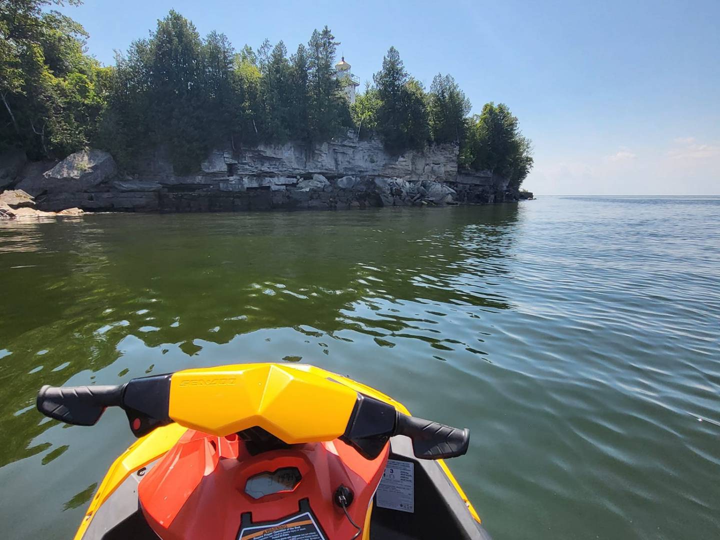 a person riding a motorcycle next to a body of water